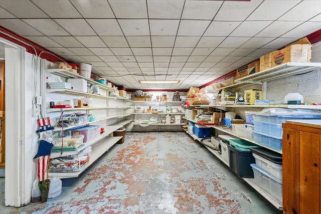 a white house that has a small yard and couches chairs with wooden fence