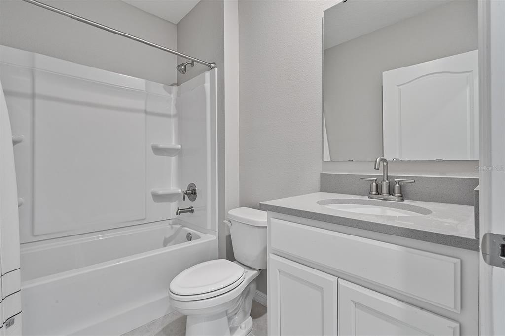 1328 Calmito Lane Mount Dora, FL 32757 - Photo 12 of 29 a bathroom with a granite countertop sink toilet and shower