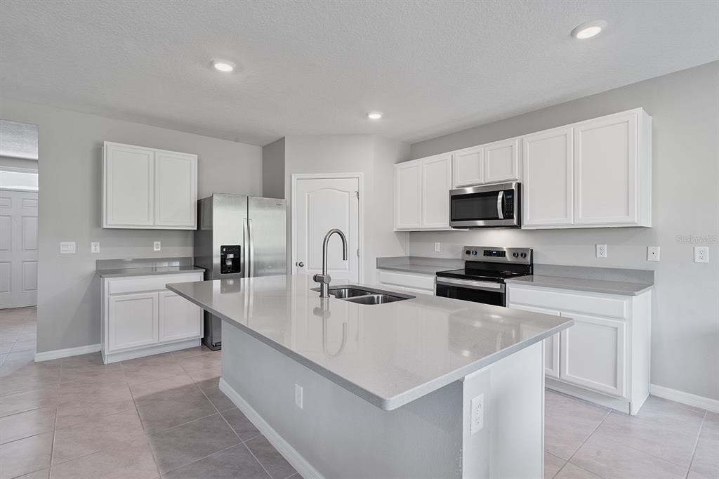 1328 Calmito Lane Mount Dora, FL 32757 - Photo 4 of 29 a kitchen with sink a microwave and cabinets