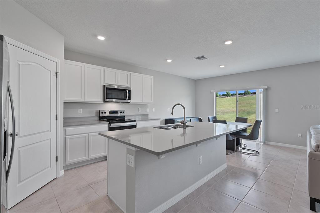1328 Calmito Lane Mount Dora, FL 32757 - Photo 5 of 29 a large kitchen with a sink stainless steel appliances and cabinets