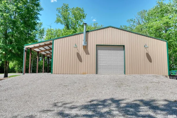 a view of a house with a yard and large trees