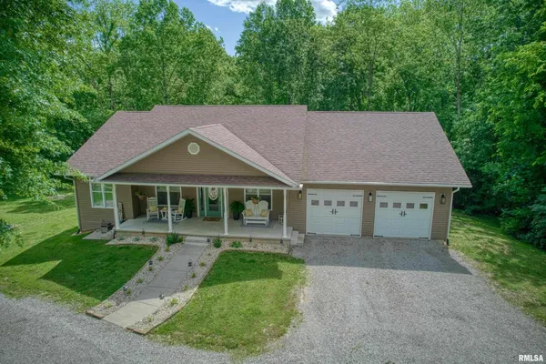 a aerial view of a house with a yard and a large tree