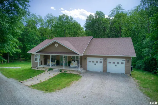 a aerial view of a house with table and chairs in a yard