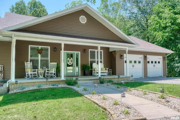 a front view of a house with a yard and plants