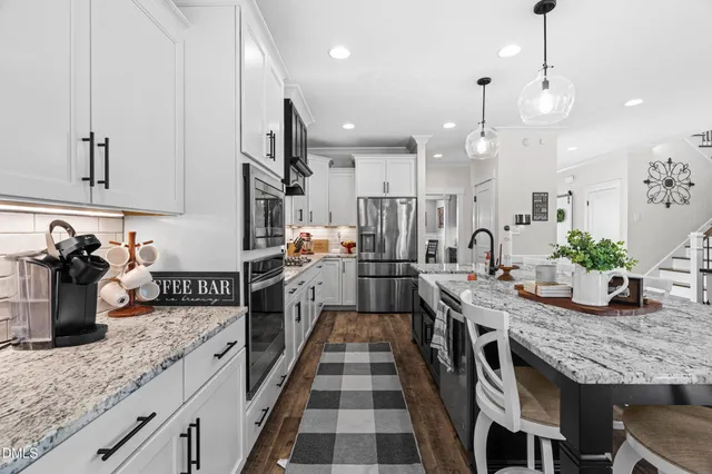 a kitchen with granite countertop kitchen island stainless steel appliances a sink counter space cabinets and a center island