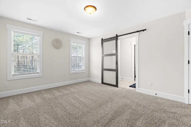 a spacious bedroom with a bed and window