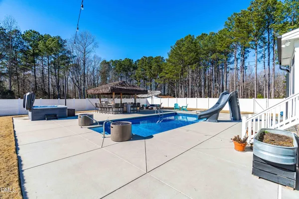 a view of patio with table and chairs under an umbrella with a barbeque
