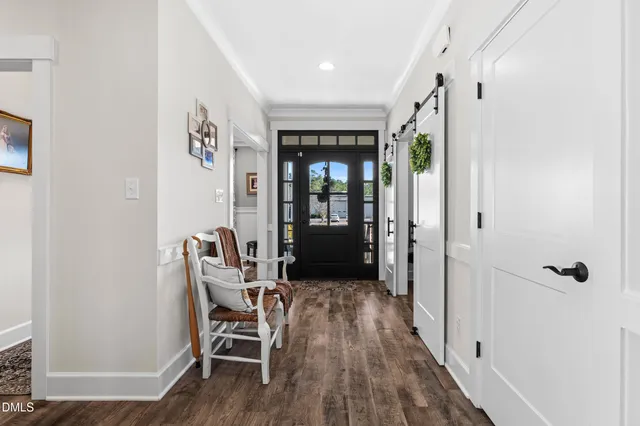 a view of a hallway with wooden floor and a bathroom