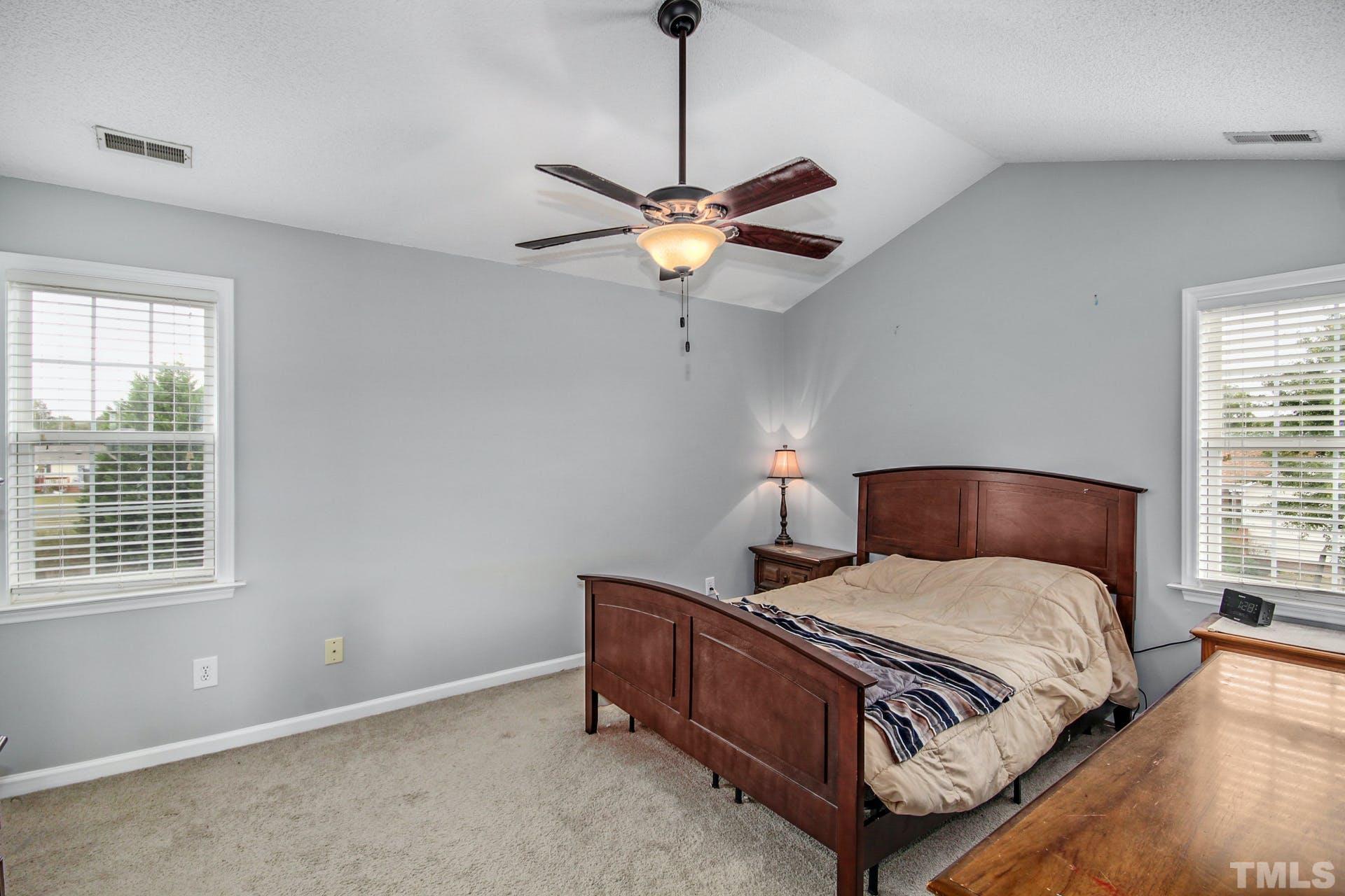 1013 Holland Ridge Drive Raleigh, NC 27603 - Photo 14 of 29 a bedroom with a bed and a chandelier