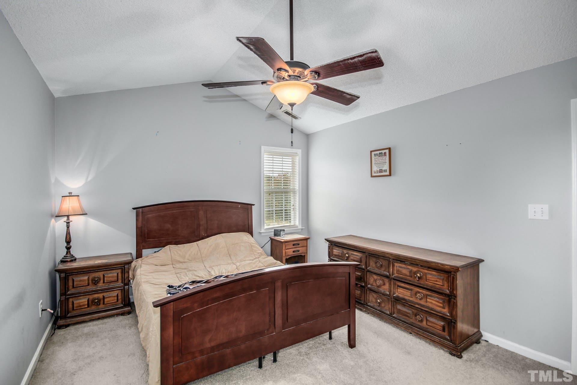 1013 Holland Ridge Drive Raleigh, NC 27603 - Photo 15 of 29 a bedroom with a bed and a chandelier