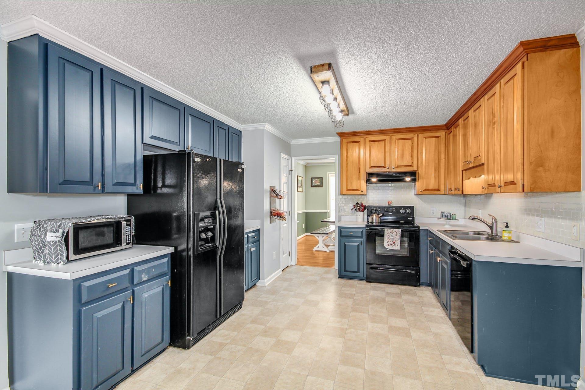 1013 Holland Ridge Drive Raleigh, NC 27603 - Photo 8 of 29 a kitchen with kitchen island granite countertop wooden cabinets stainless steel appliances and a window