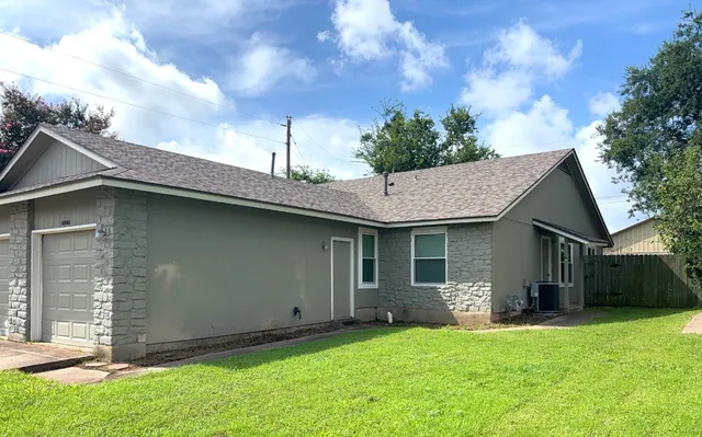 a backyard of a house with table and chairs