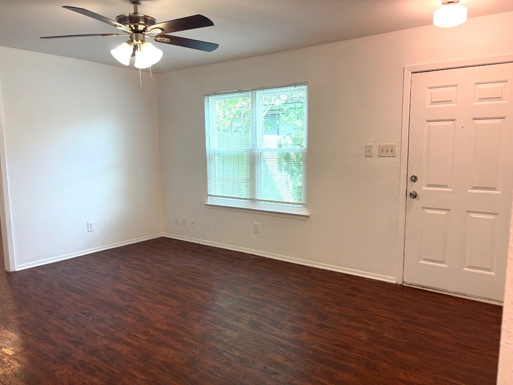 16005 Stoneham Circle Pflugerville, TX 78660 - Photo 3 of 18 a view of an empty room with wooden floor and a window