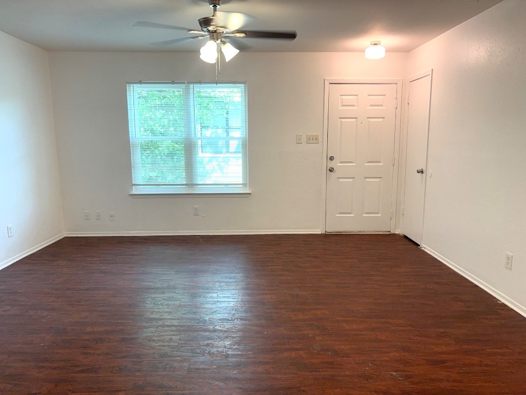 16005 Stoneham Circle Pflugerville, TX 78660 - Photo 4 of 18 an empty room with wooden floor chandelier fan and windows