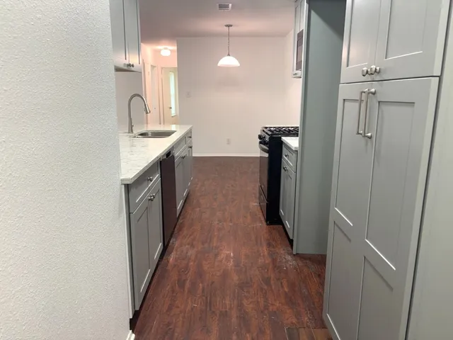 a kitchen with sink a refrigerator and wooden floor