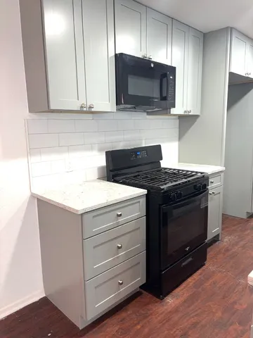 a kitchen with stainless steel appliances granite countertop wooden cabinets microwave and stove