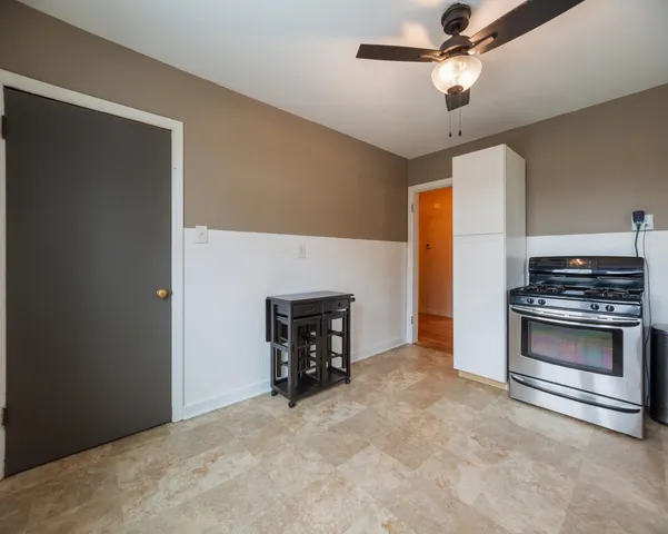 a view of empty room with a fireplace and a ceiling fan