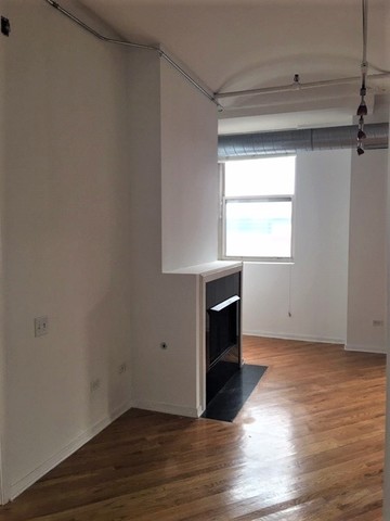 500 South Clinton Street, Unit 611 Chicago, IL 60607 - Photo 4 of 19 an empty room with wooden floor and windows