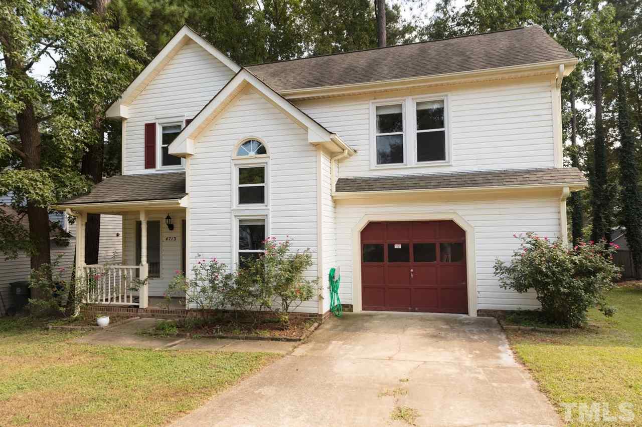 a front view of a house with a garden and garage