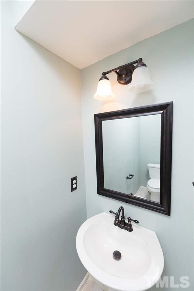 4713 Tolley Court Raleigh, NC 27616 - Photo 11 of 28 a bathroom with a sink and a mirror