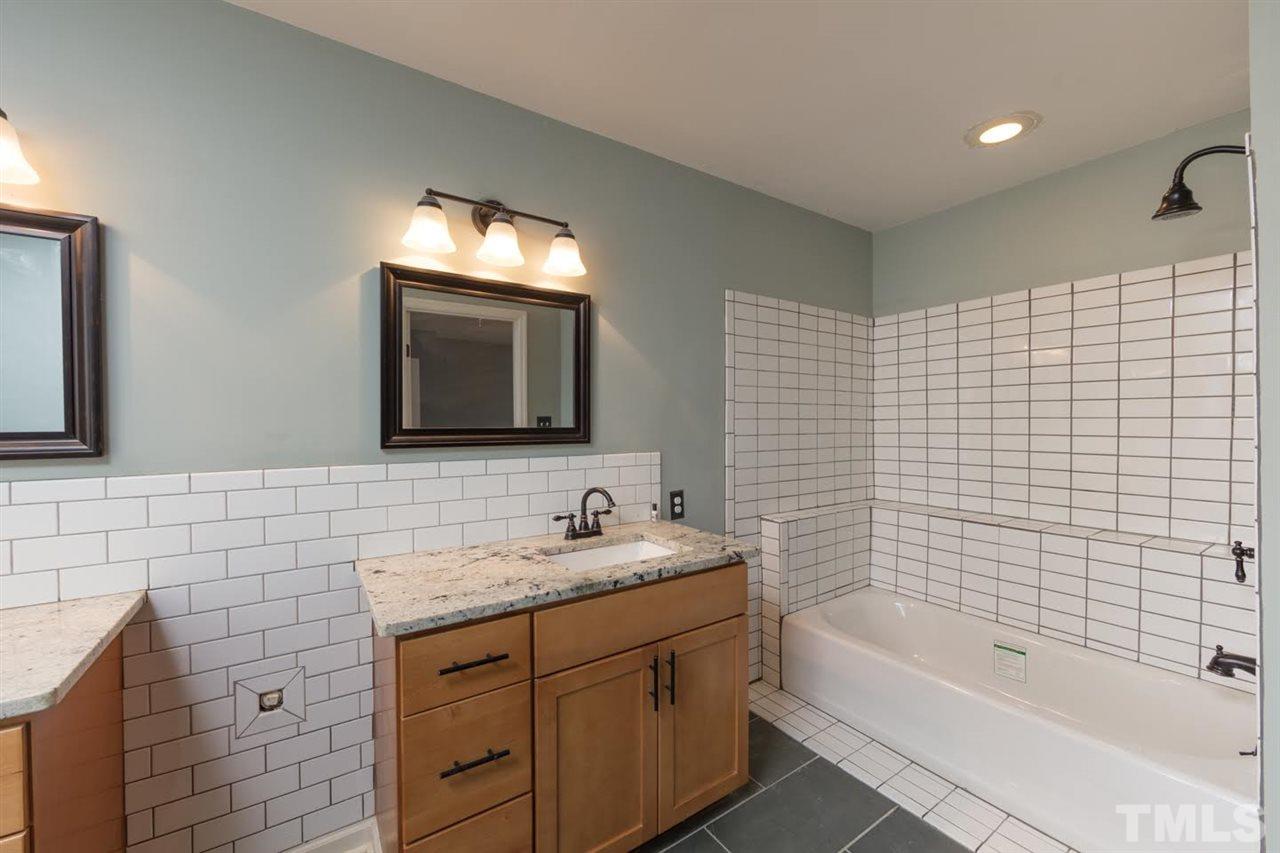 4713 Tolley Court Raleigh, NC 27616 - Photo 16 of 28 a bathroom with a sink a bathtub and a mirror