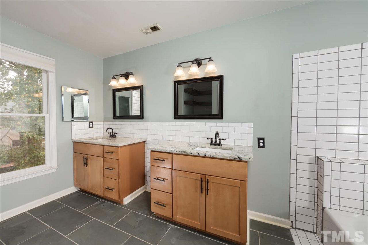 4713 Tolley Court Raleigh, NC 27616 - Photo 19 of 28 a spacious bathroom with a double vanity sink a mirror and a bathtub