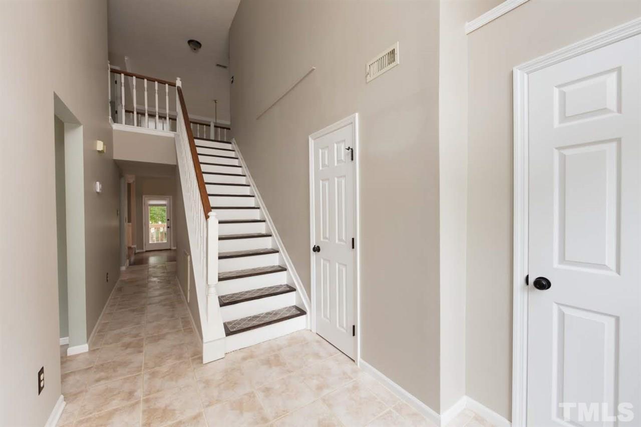 4713 Tolley Court Raleigh, NC 27616 - Photo 4 of 28 a view of a hallway with stairs and wooden floor
