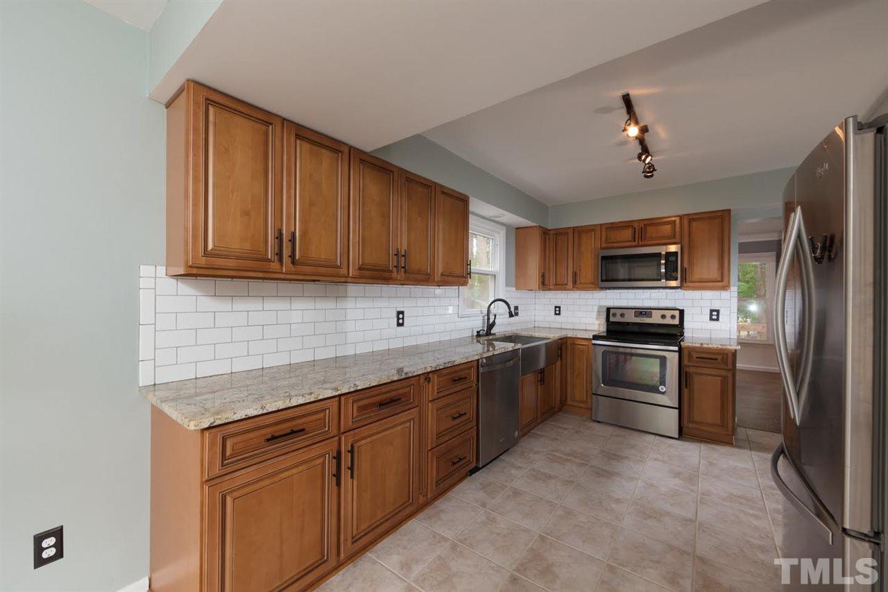 4713 Tolley Court Raleigh, NC 27616 - Photo 7 of 28 a kitchen with a sink stainless steel appliances and cabinets
