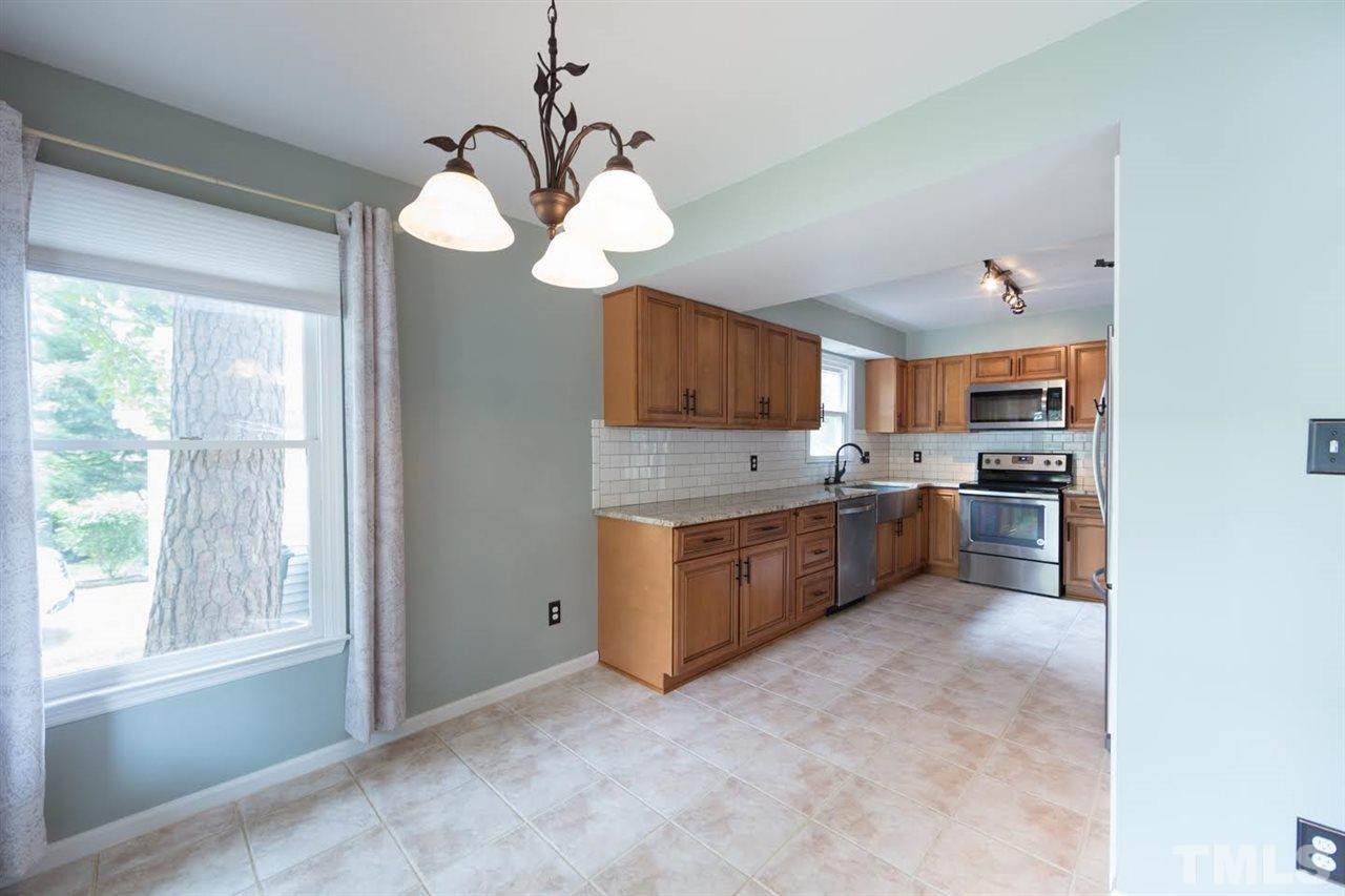 4713 Tolley Court Raleigh, NC 27616 - Photo 9 of 28 a large kitchen with a large counter top cabinets a sink and stainless steel appliances