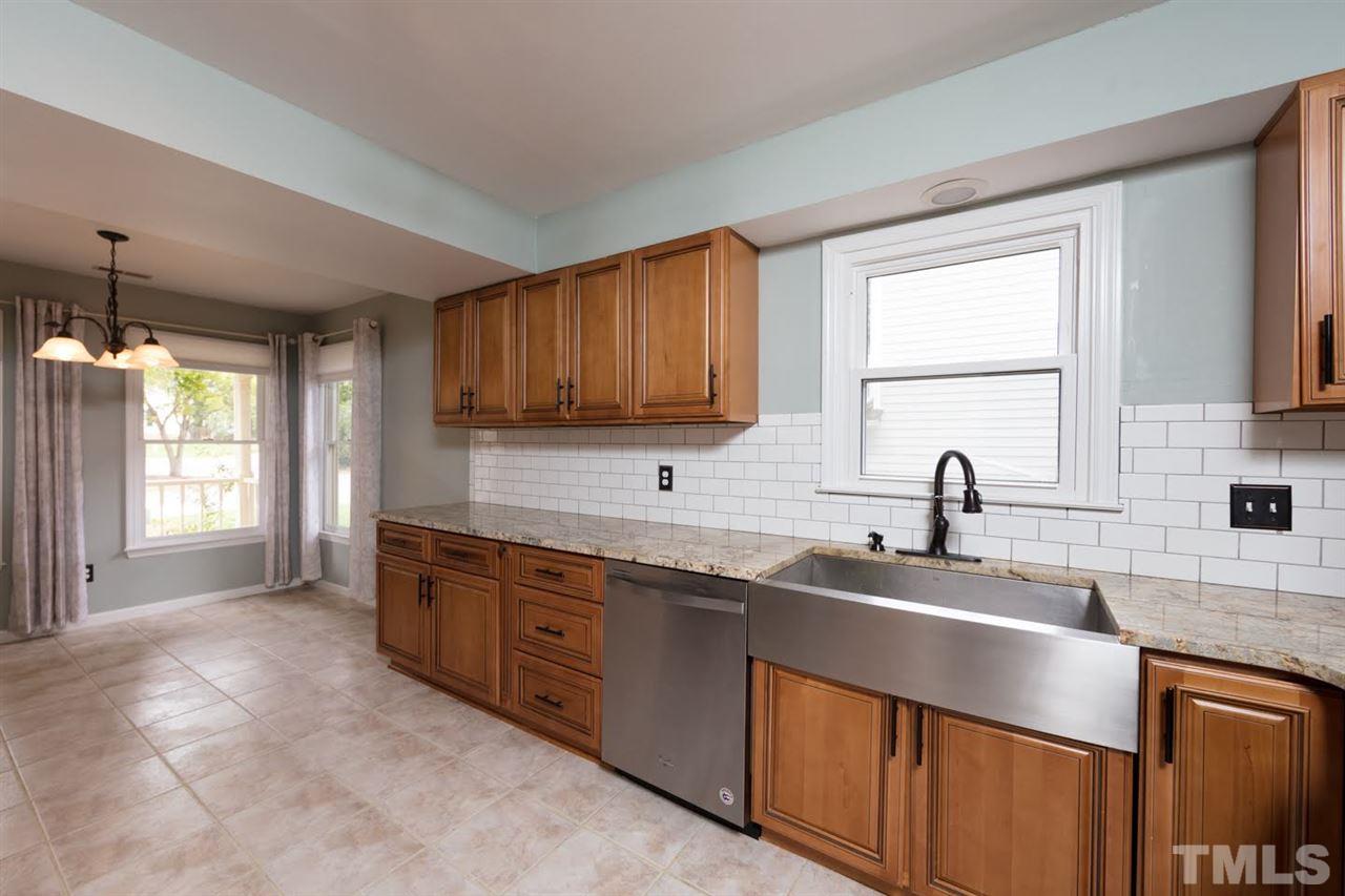 4713 Tolley Court Raleigh, NC 27616 - Photo 10 of 28 a kitchen with stainless steel appliances granite countertop a sink stove and cabinets