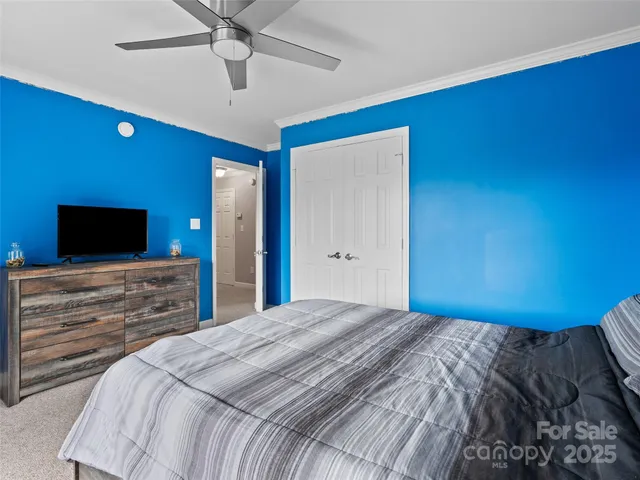 a bedroom with a large bed and a chandelier