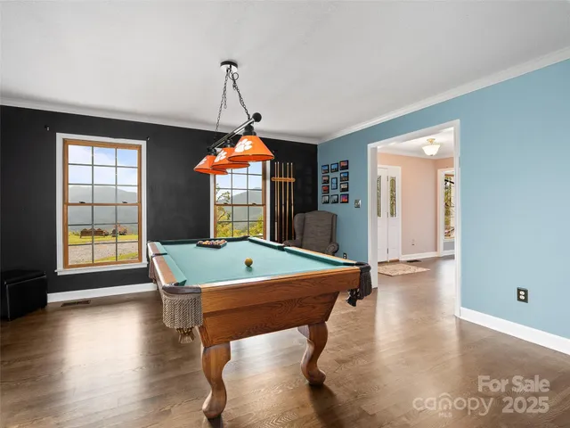 a room with pool table and windows