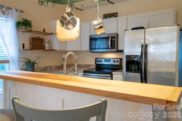 a kitchen with refrigerator and microwave