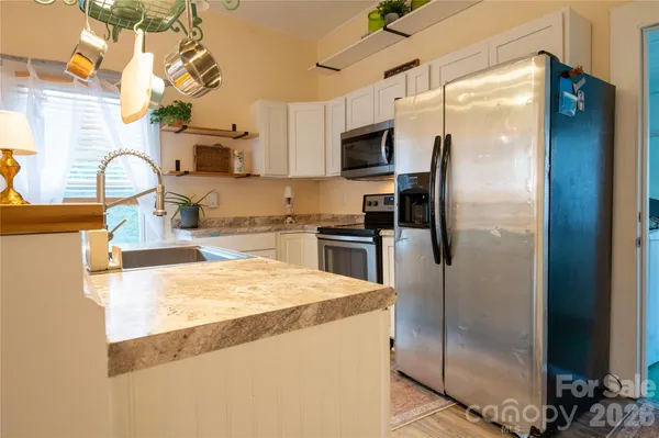 a kitchen with stainless steel appliances granite countertop a refrigerator a stove and a sink
