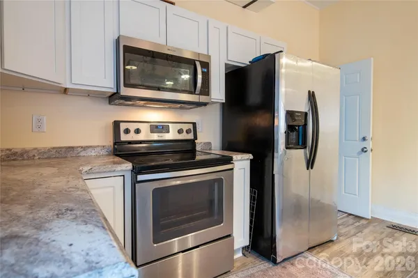 a kitchen with stainless steel appliances granite countertop a refrigerator stove and microwave