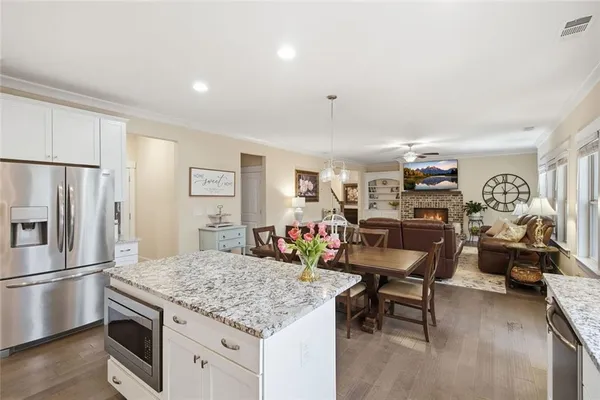 a kitchen with stainless steel appliances kitchen island granite countertop a refrigerator and a stove top oven