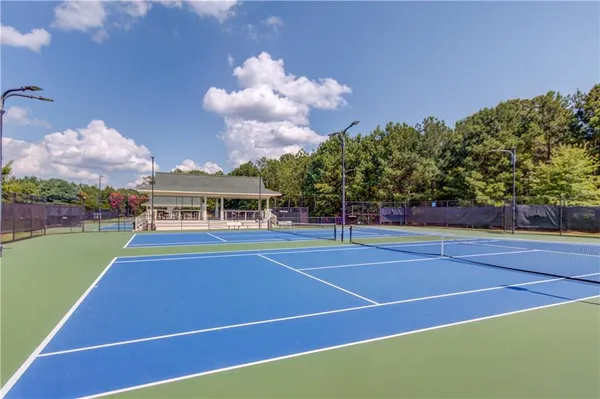 an aerial view of a residential houses with outdoor space and trees all around