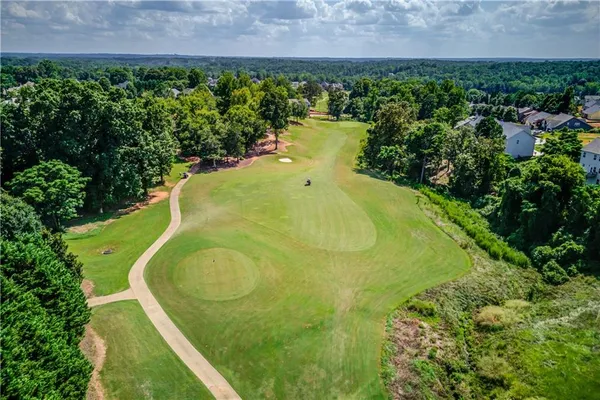 an aerial view of a house with a garden and lake view