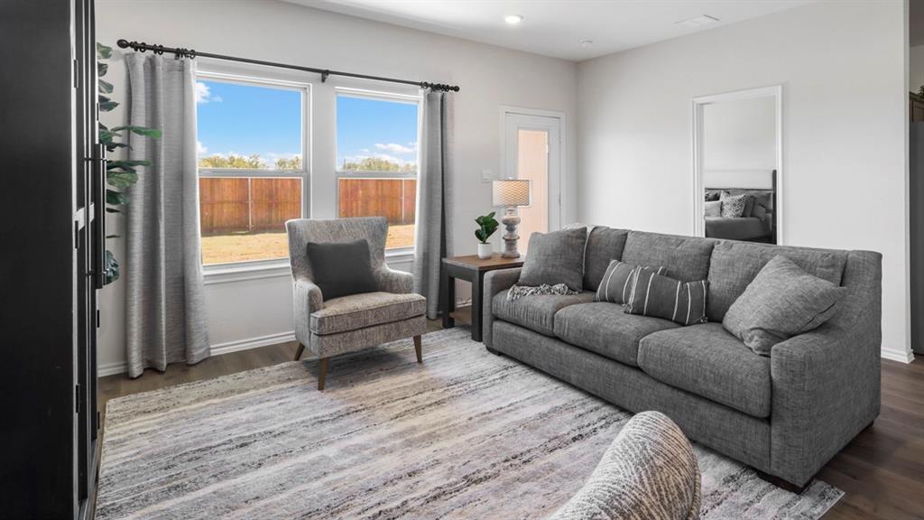 636 Dunham Road Nevada, TX 75173 - Photo 22 of 31 Spacious living area featuring wood-finish flooring, light-colored walls, and large windows overlooking a fenced yard