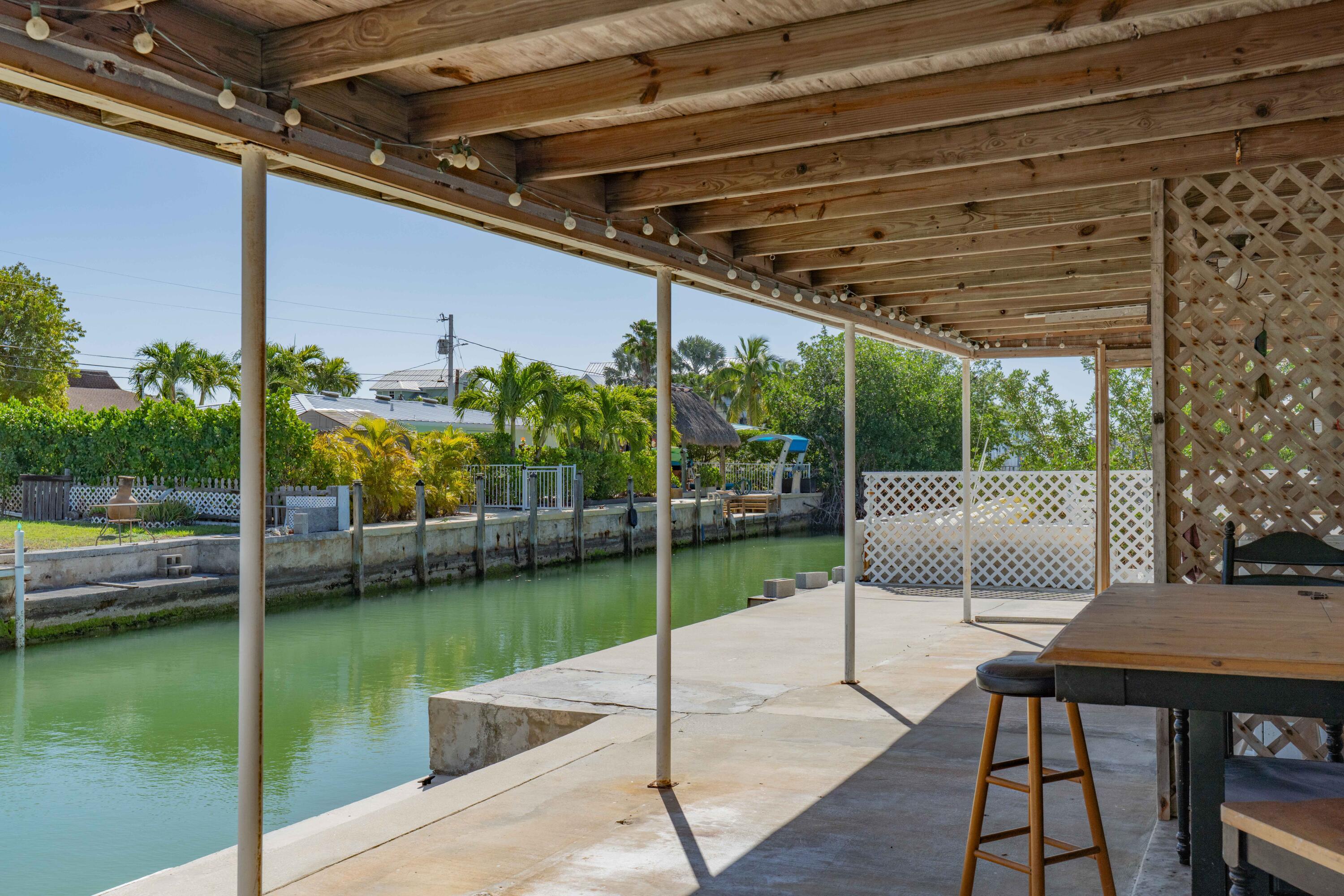798 96th Street Marathon, FL 33050 - Photo 3 of 28 a view of a chair and tables in the patio next to a yard