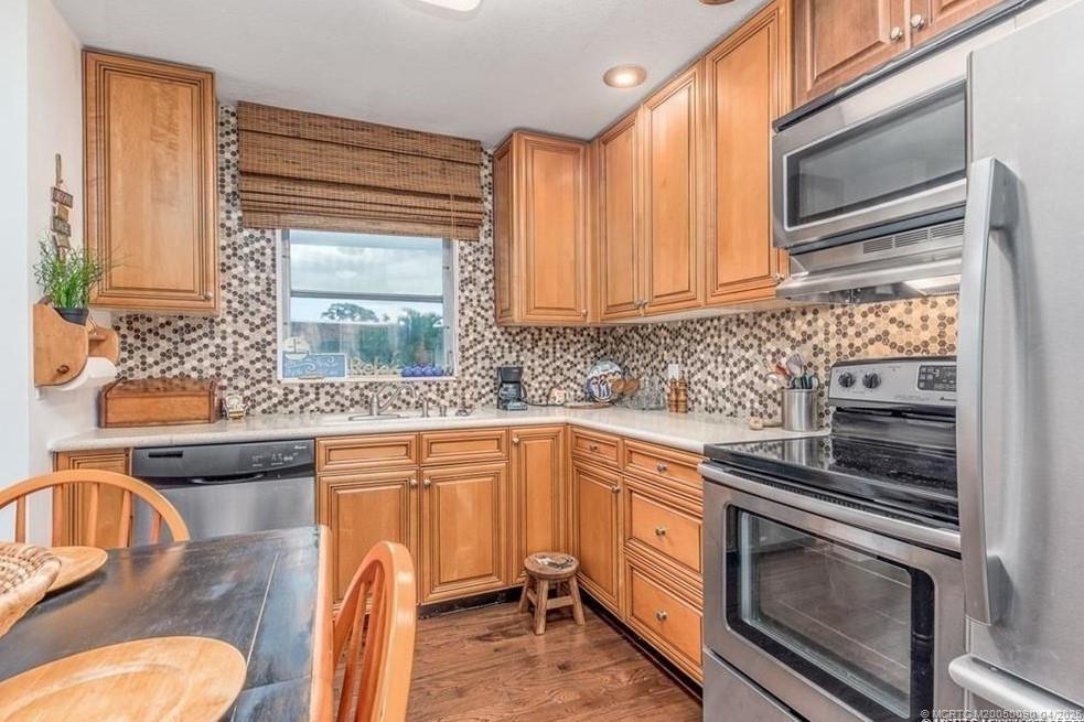 2950 Southeast Ocean Boulevard, Unit 66 Stuart, FL 34996 - Photo 3 of 18 a kitchen with granite countertop a sink stainless steel appliances and cabinets