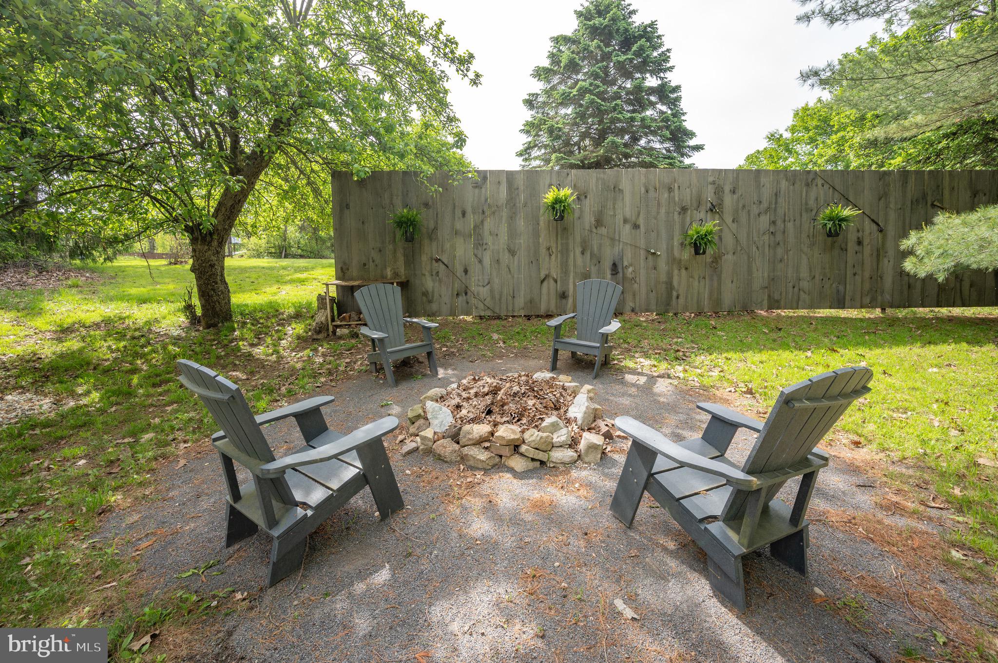 560 Glendale Road Oakland, MD 21550 - Photo 22 of 24 a view of a backyard with chairs potted plants and a large tree
