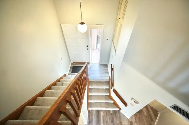 a view of a staircase with wooden floor and white walls