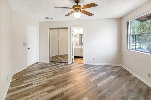 a view of empty room with window and ceiling fan