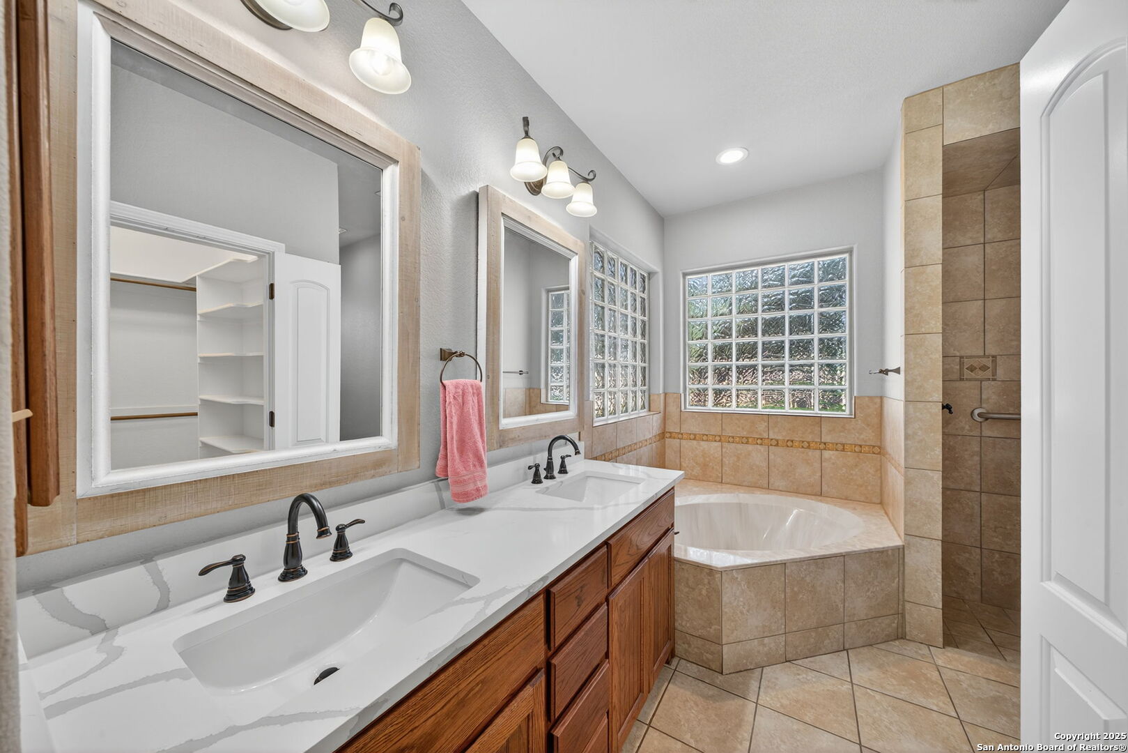 1626 Clover Ridge Pleasanton, TX 78064 - Photo 15 of 33 a bathroom with a bathtub a double vanity sink and mirror