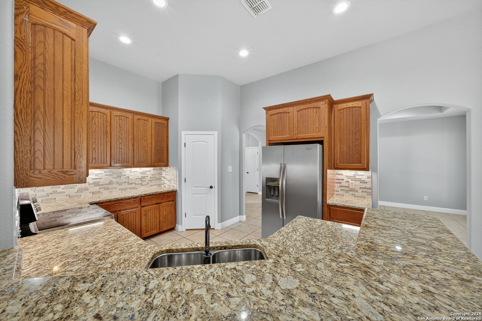 1626 Clover Ridge Pleasanton, TX 78064 - Photo 7 of 33 a kitchen with stainless steel appliances kitchen island granite countertop a refrigerator and a sink