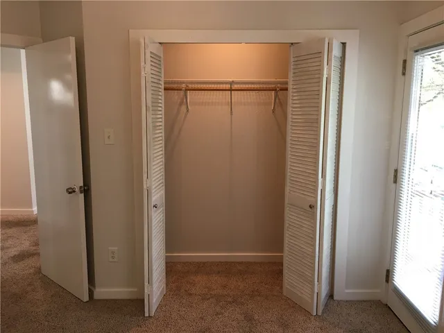 an empty room with windows and closet