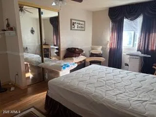 a bedroom with a bed and a large mirror with a bathroom