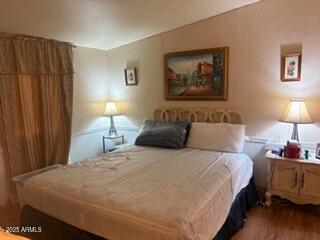 17230 Iron Springs Road Munds Park, AZ 86017 - Photo 29 of 42 a bedroom with bed and wall painting with wooden floor