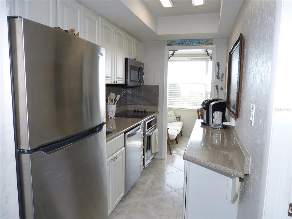 2 Causeway Boulevard, Unit 206 Dunedin, FL 34698 - Photo 13 of 26 a kitchen with a refrigerator and a sink